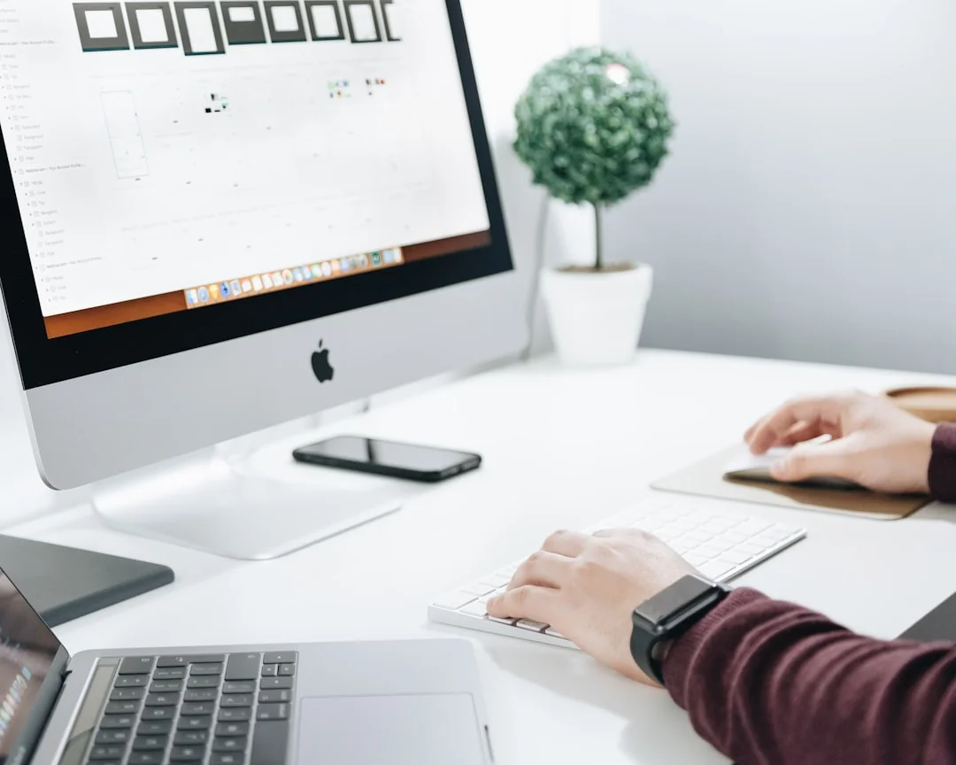 A modern workspace featuring dual computer monitors displaying web design projects, emphasizing technology and productivity.