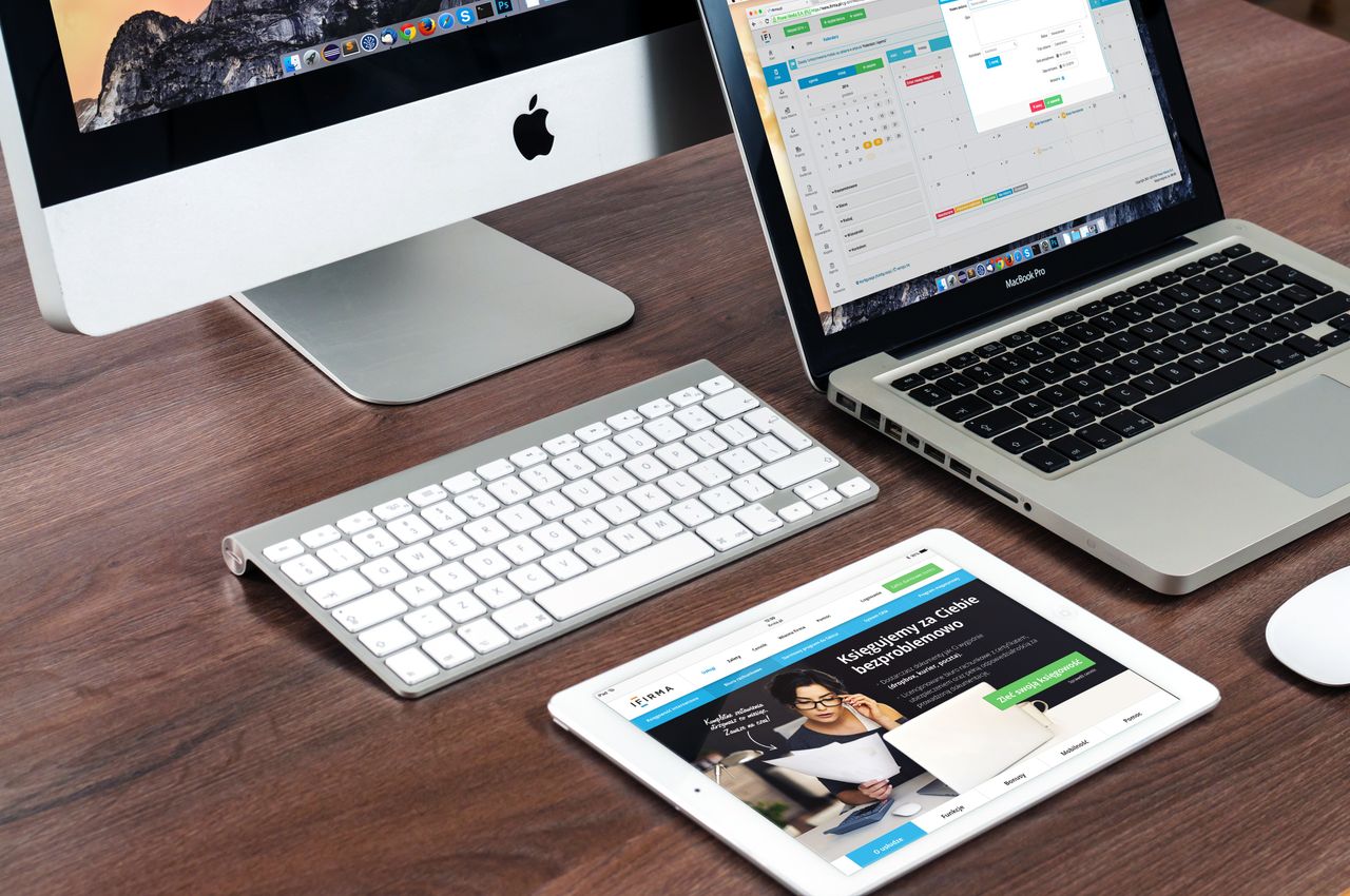 A refined office desk arrangement showcasing Apple devices: iMac, MacBook, and iPad.